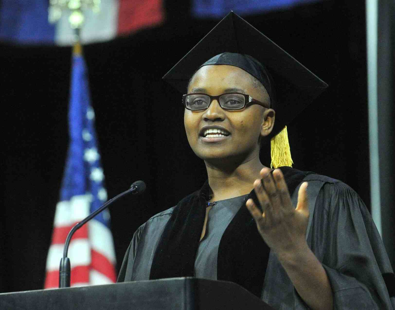 Nelly Cheboi at Augustana 2023 commencement on stage with her left hand up