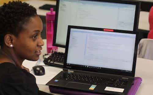 Nelly Cheboi coding on her laptop at Augustana College